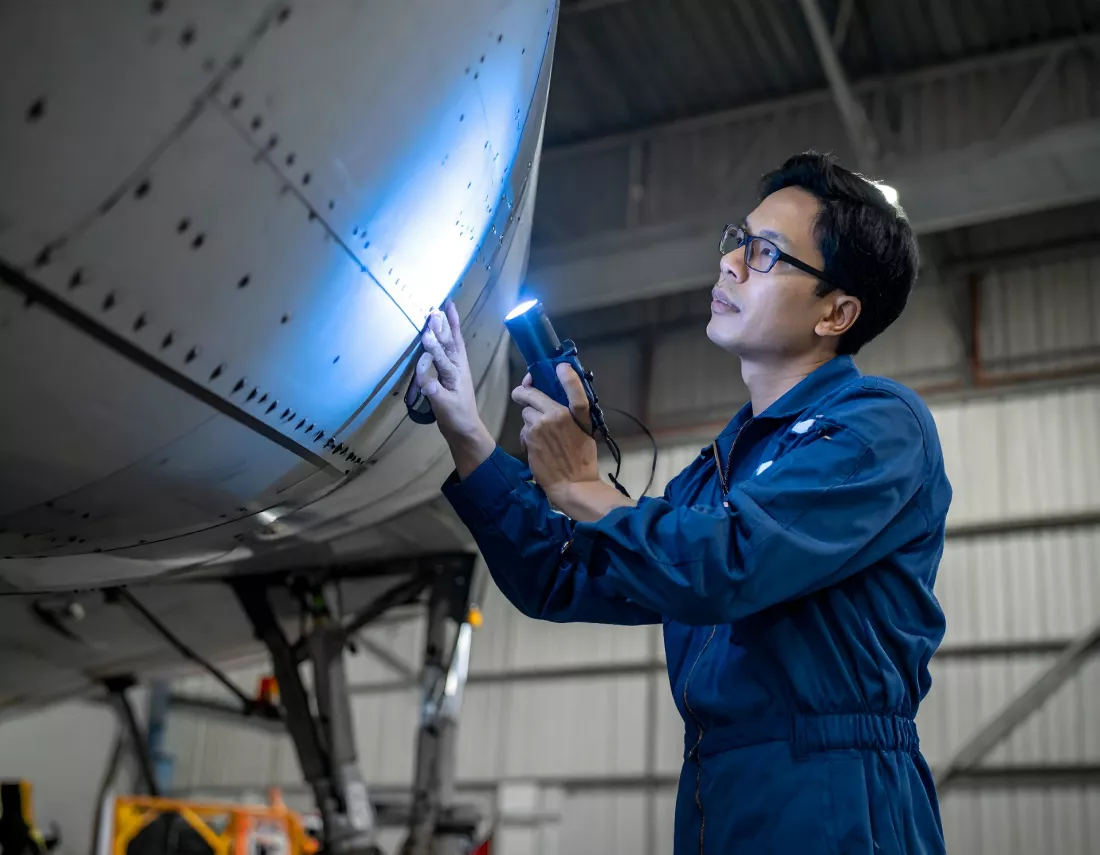 Un tecnico inspecciona un avion en el hangar